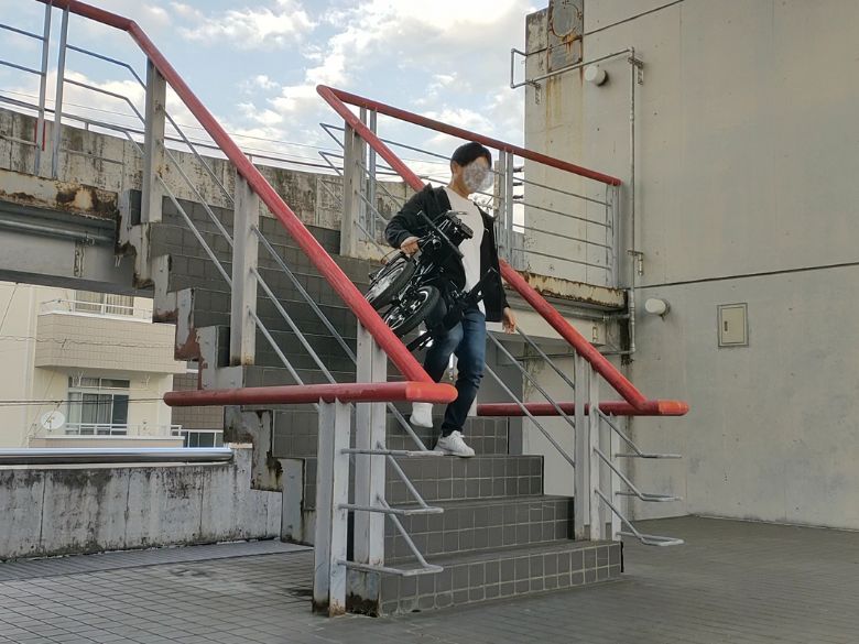 片手で持って階段を下りる